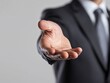 © Nana - A businessman extends a hand, suggesting a greeting or offer.