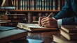 © Jasmine - Lawyer's hand writing in a notebook, surrounded by legal books and case files