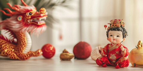 a small child doll sits next to a dragon doll surrounded by Chinese New Year ornaments on a table. lots of empty space for text. light background blur