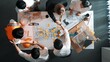 © InfiniteFlow - Top down aerial view of smart architect engineer team pointing and discussing about building construction. Group of diverse people work together to plan and shake hand and making deal. Alimentation.