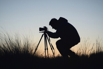 Wall Mural - Photographer capturing silhouettes at sunset