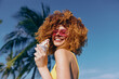 © SHOTPRIME STUDIO - Joyful woman enjoying ice cream under palm trees in sunny weather