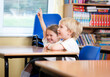 © track5 - Elementary School: Eager Pupils. A pair of eager primary school pupils sitting at a desk in a classroom eager to be involved with the lesson.