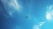 © dePICsignSTOCKS - Passenger jet airplane flying above clouds. Airplane in the blue sky with clouds from below, high flying passenger plane