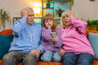 © Andrii Iemelianenko - Upset grandfather, grandmother and granddaughter playing game on smartphone losing at home. Sad Caucasian girl with senior grandparents received bad news fortune loss fail education study test on sofa