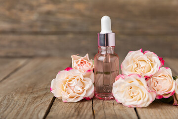 Wall Mural - Rose essential oil on a textured background.Roses and a bottle of rose perfumed water.Aromatherapy treatment. Beauty concept. Spa procedure.Natural organic oil.Anti-stress,detox relax.Place for text