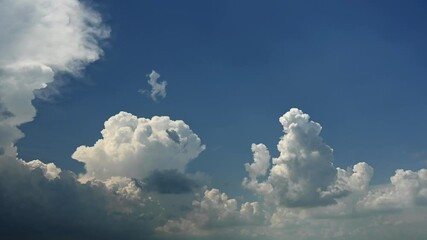 Wall Mural - time lapse of churning and growing storm clouds building in a blue sky.
