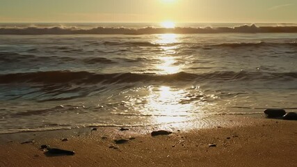 Wall Mural - golden sunset on a beach, foamy waves rolling towards white sand beach under low the sun light
