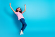 © deagreez - Full length photo of cheerful pretty lady dressed pink t-shirt earphones dancing empty space isolated blue color background