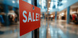 © Aziz - Red sale tag hanging in a retail store with a blurred background of clothes and lights, representing retail sales, discounts, and promotions