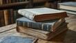 © gentho - A stack of old books on a wooden table, showcasing their worn covers and pages.