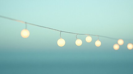 Poster - String of warm-toned, glowing globe lights against a soft blue sky at sunset.