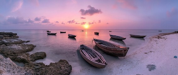 Poster - Serene sunset over tranquil ocean with several wooden boats on the shore.