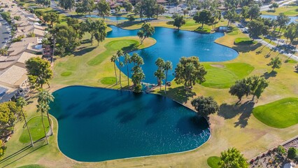 Canvas Print - Aerial view of a lush golf course with water features.