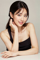 Wall Mural - A woman with long black hair and a black tank top is sitting at a table