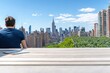 © EpicFade - Person Enjoys Scenic View of Manhattan Skyline from Rooftop Garden on Sunny Day