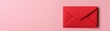 © nattapon98 - A vibrant red envelope rests against a soft pink background, creating a striking visual contrast, ideal for conveying messages or invitations.