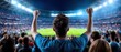 © khonkangrua - Excited Fan Cheering in a Stadium During a Live Sports Event with Joyful Atmosphere and Bright Floodlights