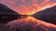 © milenialdesastudio - Vibrant sunrise paints the sky with fiery hues over a tranquil lake and wooden pier.