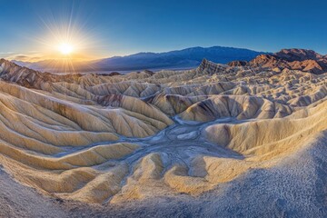 Wall Mural - A wide shot of the desert landscape with the sun shining overhead, in Death Valley National Park, California, USA. The vast expanse under the blue sky is dotted by rugged rock formations and sparse 