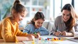 © Vilaysack - A joyful scene of a mother and her two daughters engaging in a creative activity together at home, filled with smiles and colorful materials.