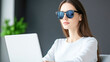 © Kowit - Professional woman in sunglasses working on laptop in modern home office
