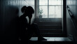 © Jānis Pūne - mental health concept, silhouette of a woman sitting against the wall crying. feeling alone, dark picture with sad vibes