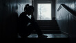 © Jānis Pūne - mental health concept, silhouette of a woman sitting against the wall crying. feeling alone, dark picture with sad vibes