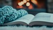 © Angelina - Cozy Winter Escape: Beside a soft blue knitted blanket, a book is left open, inviting relaxation by a warm fireplace on a chilly night. The image instills a sense of peace, comfort, and tranquility.