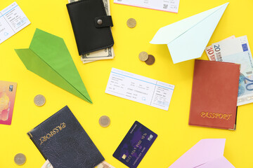 Wall Mural - Composition with paper planes, tickets, passports and money on yellow background