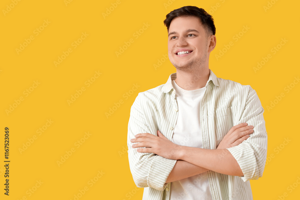 Handsome young happy smiling man on yellow background