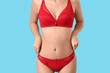 © Pixel-Shot - Beautiful young woman in sexy red underwear on blue background, closeup