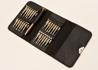 Wall Mural - A leather purse with a screwdriver and bits. A set of different screwdrivers.