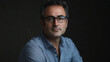 © VicPhoto - Retrato de hombre con gafas y camisa azul sobre fondo oscuro