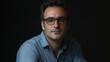 © VicPhoto - Retrato de hombre con gafas y camisa azul sobre fondo oscuro