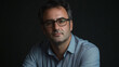 © VicPhoto - Retrato de hombre con gafas y camisa azul sobre fondo oscuro