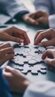 © Galaxyd - Hands joining jigsaw puzzle pieces, teamwork concept.