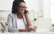 © Prostock-studio - African American Business Woman Having Phone Conversation Working On Laptop In Modern Office. Empty Space