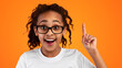 © Prostock-studio - Wow, Eureka. Heashot portrait of emotional black student girl having great idea, finding inspiration or solution to problem. Excited pupil in glasses with open mouth pointing finger up, studio wall