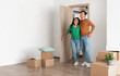 © Prostock-studio - Relocation Concept. Happy millennial newlyweds walking in new empty house with cardboard boxes on floor, young family of two people moving into bought apartment, excited guy and lady choosing flat