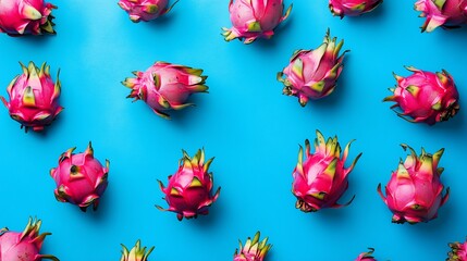 Wall Mural - A vibrant arrangement of dragon fruits on a blue background, showcasing their unique appearance.