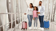 © Prostock-studio - Cheerful African American Family Standing In Airport Terminal, Holding Suitcases, Passports And Tickets, Looking At Window, Waiting For Departure. Mum, Dad And Daughter Travelling Together