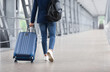 © Prostock-studio - Rear View Of Unrecognizable Man Walking With Suitcase In Airport Terminal, Male Traveller Going To Flight Boarding Gate, Ready For Vacation Journey Or Business Trip, Cropped Image, Copy Space