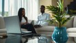 © zacty6 - Cozy modern living room setting featuring a laptop, a potted plant, and a couple engaged in conversation, emphasizing connection and technology in daily life
