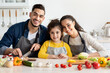 © Prostock-studio - Portrait Of Beautiful Happy Middle Eastern Family With Little Daughter Cooking In Kitchen, Cheerful Arabic Parents And Cute Female Child Smiling At Camera While Preparing Food At Home Together