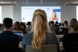 © Centric  - Audience attending a business conference presentation following the speaker on a large screen in a large auditorium