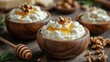 © Wan - Creamy cottage cheese topped with honey and walnuts in wooden bowls.