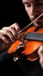 © kokoson6 - A close-up of a man playing a violin, capturing the intricate details of his hands and the instrument against a dark background.