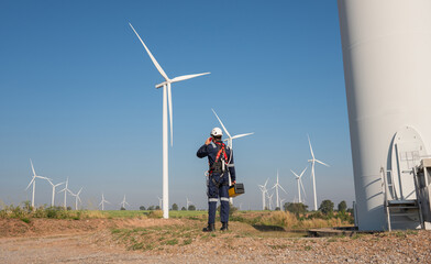 engineer wearing uniform inspection and survey work in wind turbine farms rotation to generate elect