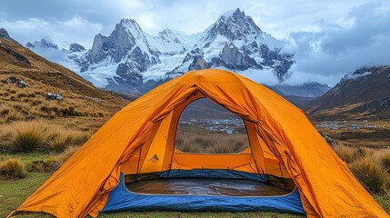 Wall Mural - Orange tent pitched in grassy field with majestic snow-capped mountains in background.